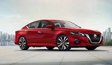 2023 Nissan Altima in red with city in background illustrating last year's 2022 model in Tony Serra Nissan in Cullman AL